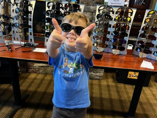 Little boy holding two thumbs up with sunglasses on